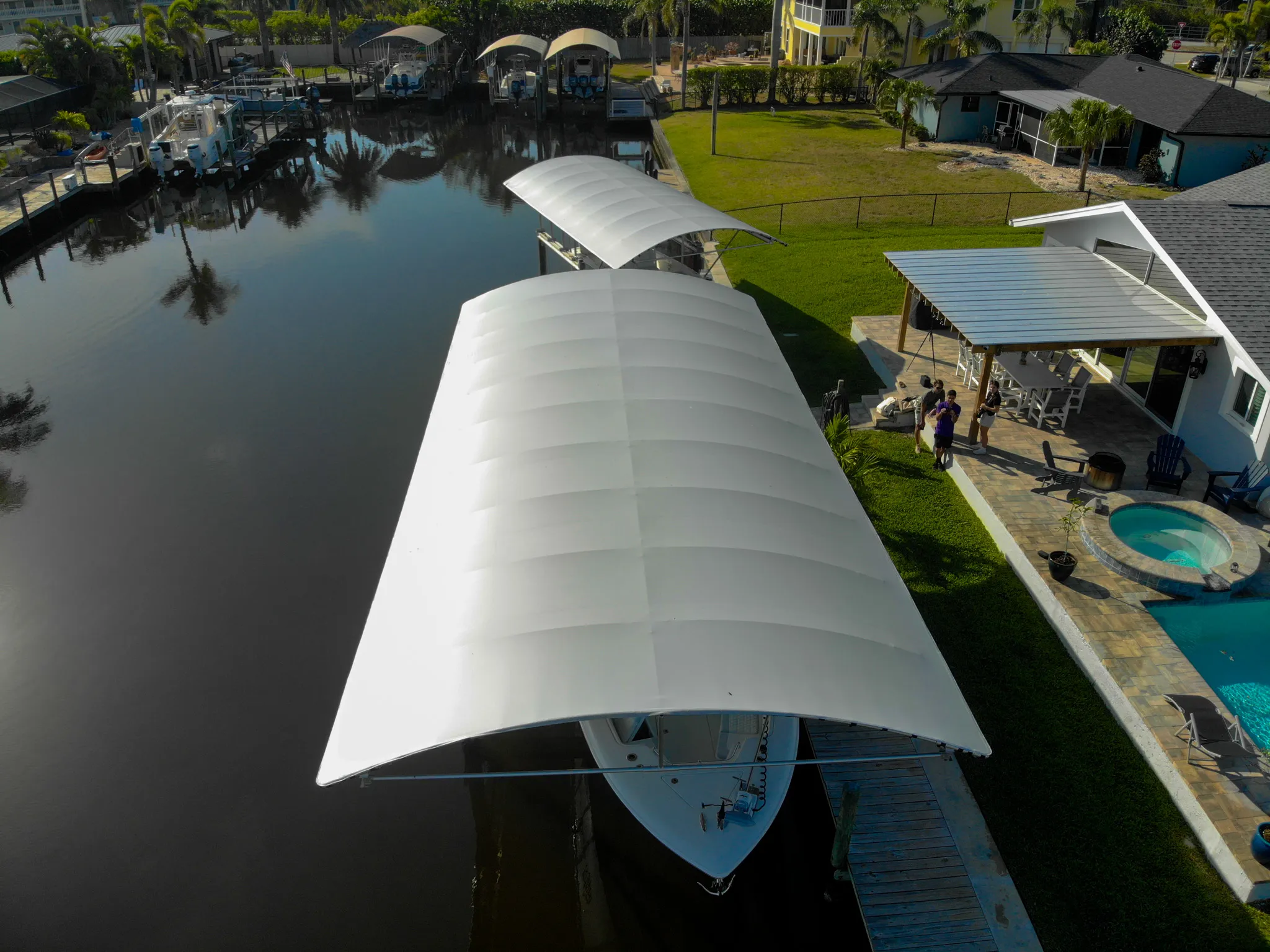 Boat lift canopy covering a cradle lift on a Southwest Florida dock with pilings