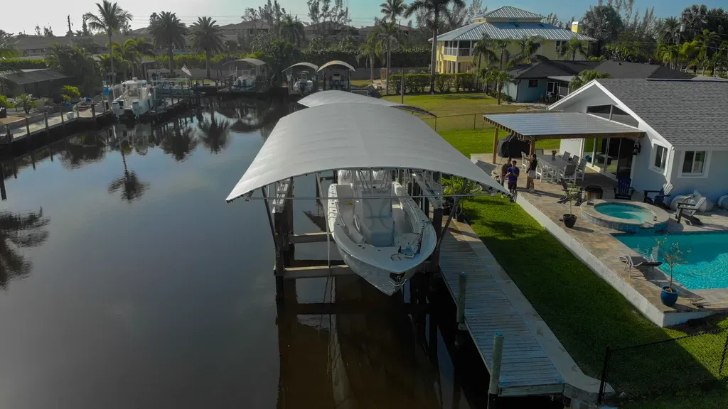 Aerial view of a boat lift canopy covering a pontoon at a waterfront dock in Florida