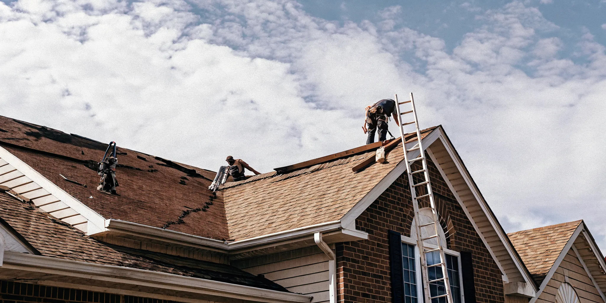 Roofing crew repairing a storm-damaged residential roof in a New Jersey suburb