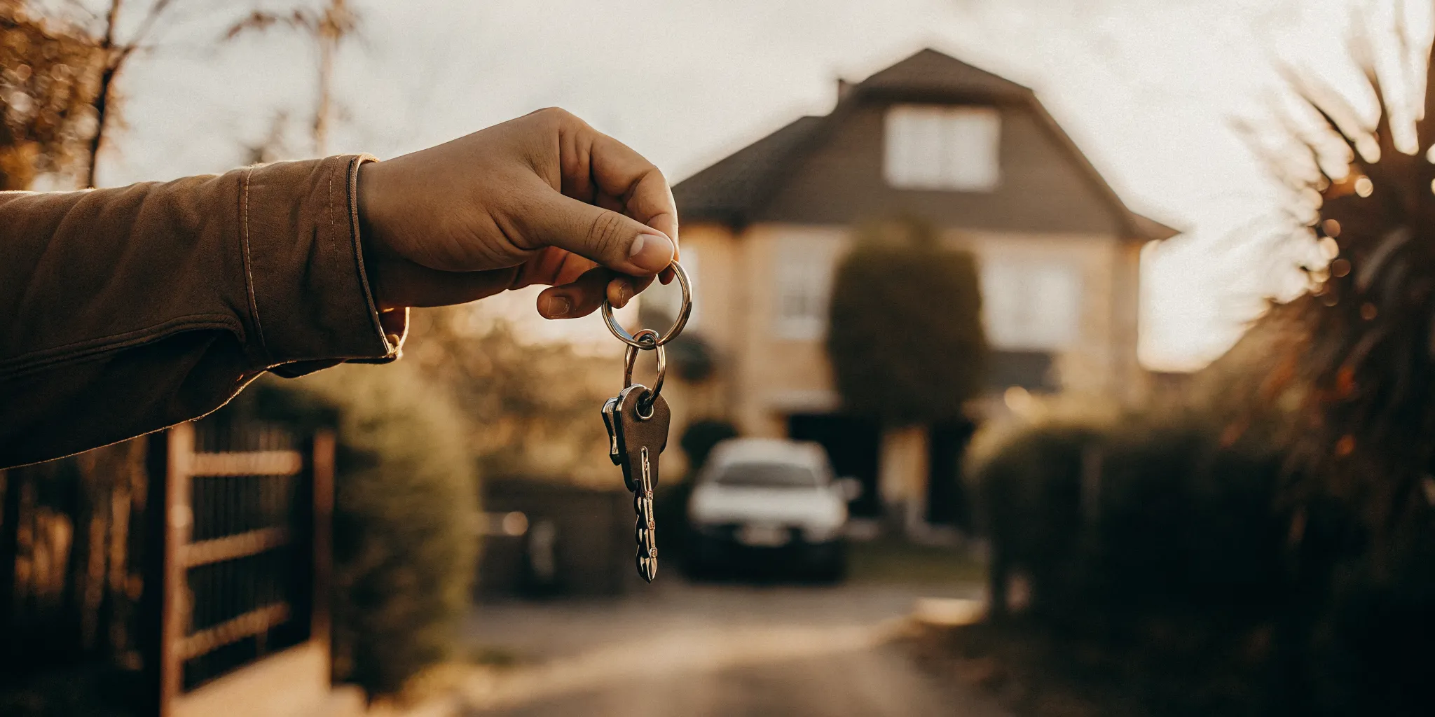 Investor standing in front of a single-family rental home with a second investment property visible in the distance