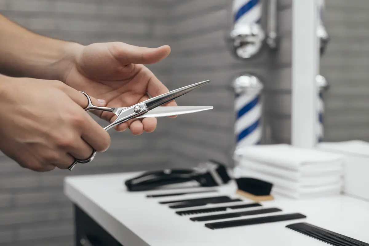 Barber checking the pivot and blade movement while adjusting professional haircutting shears