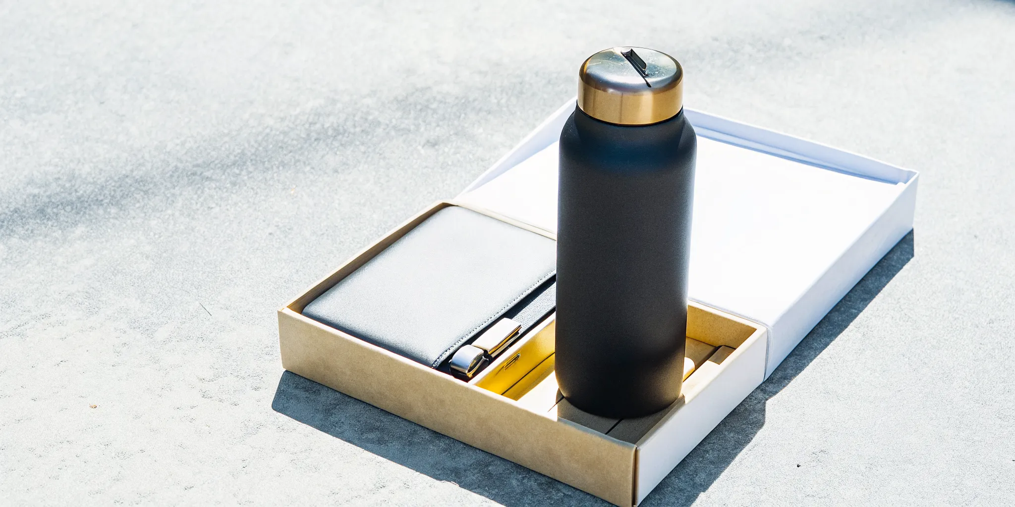 A sleek custom vacuum-insulated water bottle and custom power bank set in a welcome box.
