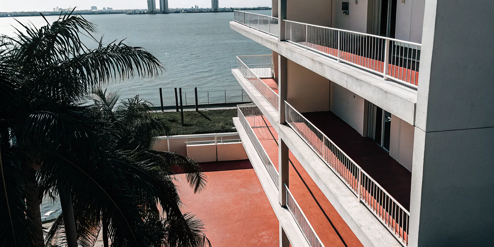 Aerial view of luxury Miami condominium towers along the waterfront with bay views and palm trees