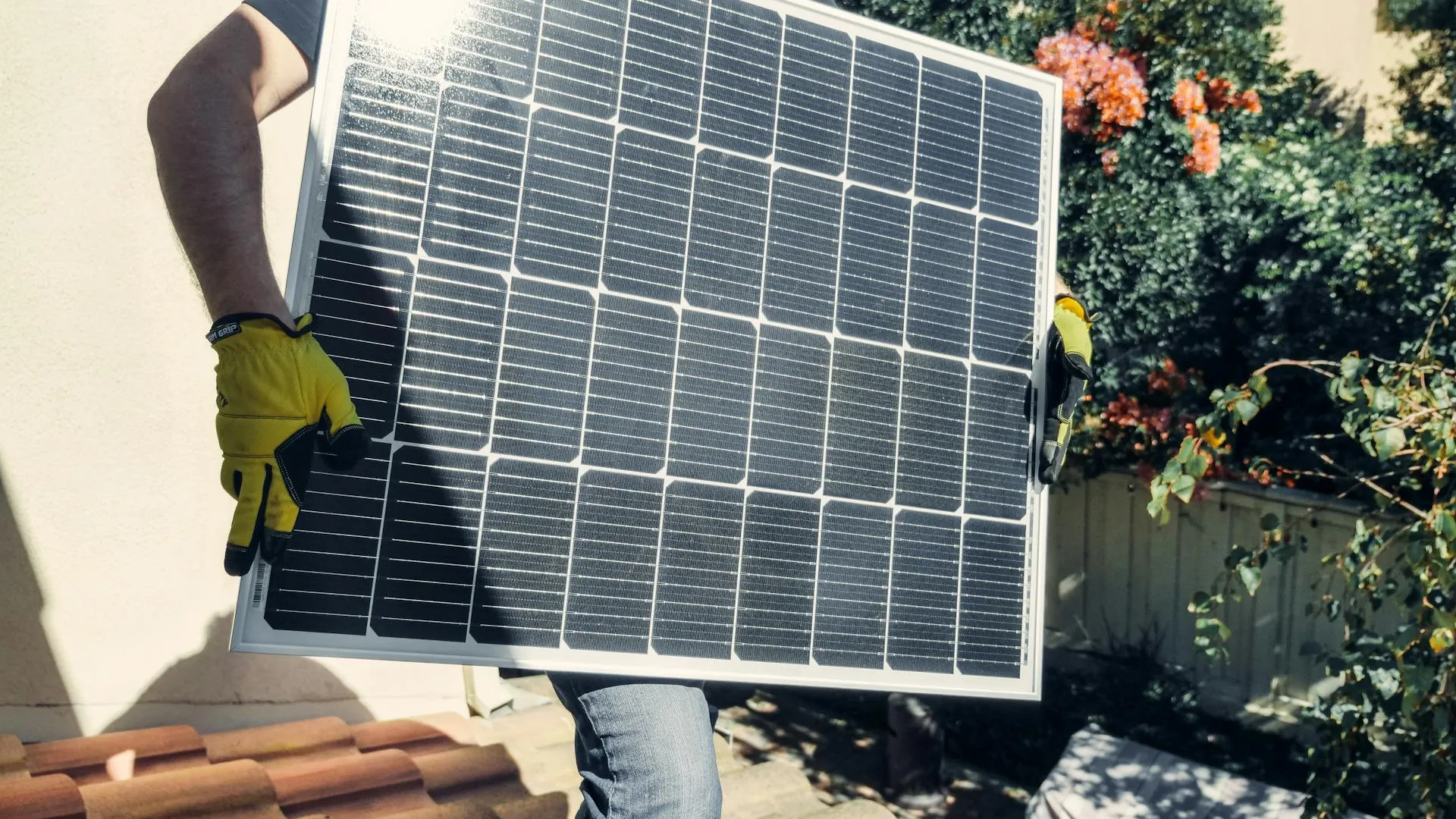 Professional solar technician inspecting residential solar panels with safety equipment on a California rooftop