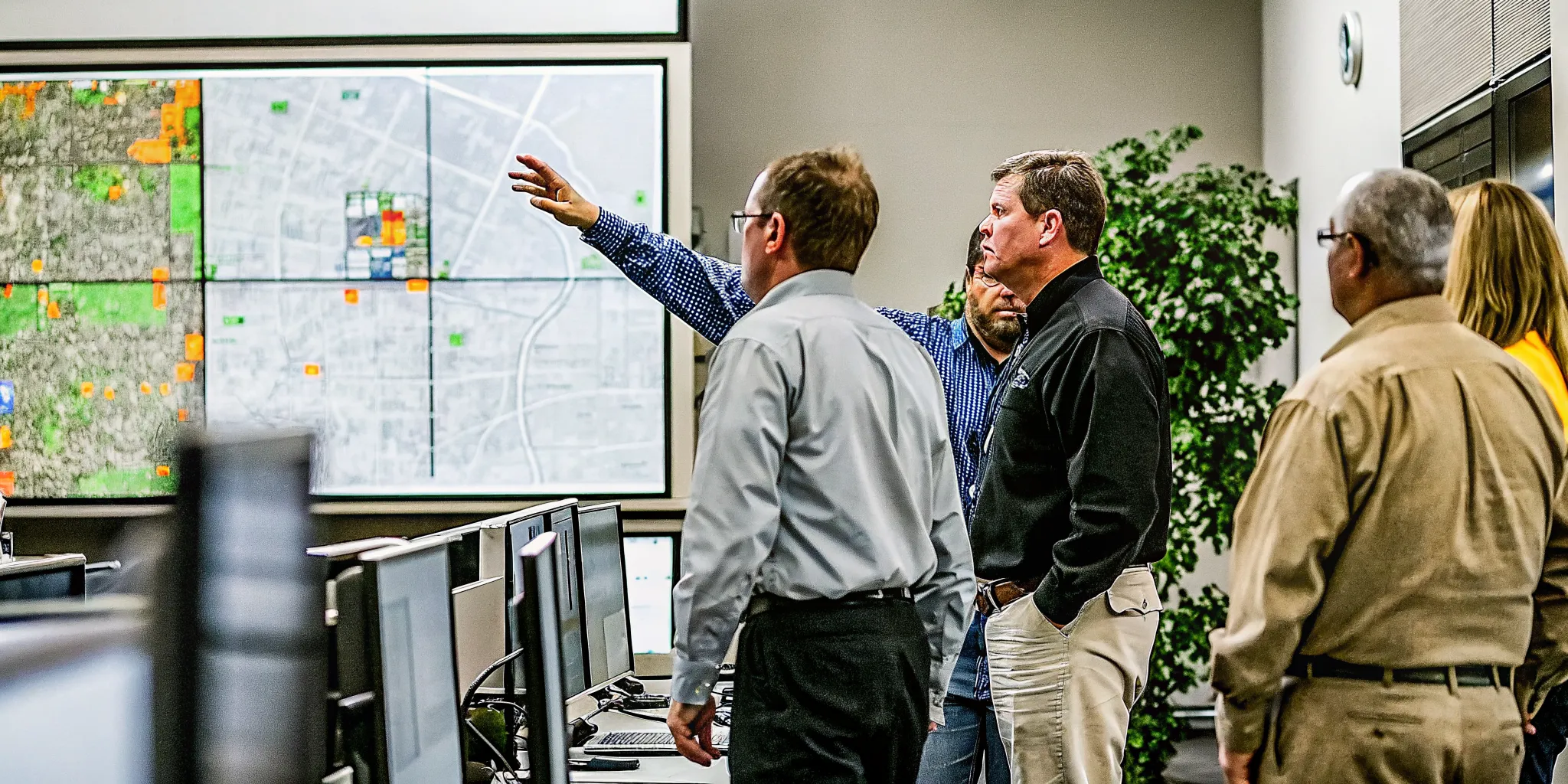 Emergency operations center with local government officials coordinating disaster response using digital maps