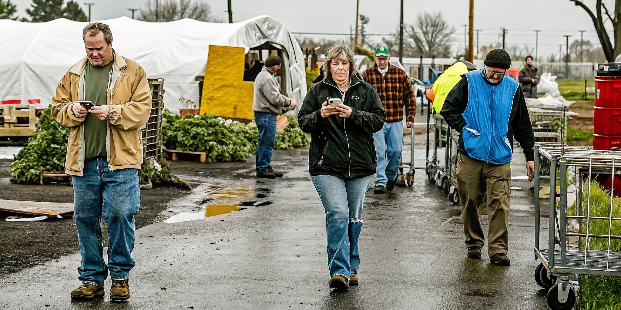 Emergency response volunteers at a disaster relief staging area tracking their hours on mobile devices
