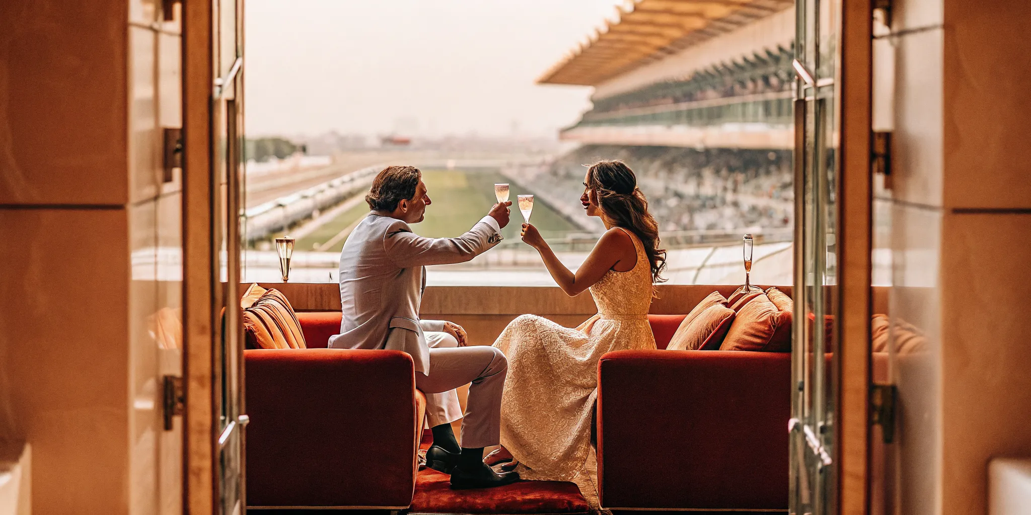 Couple toasting during luxury sports event travel for a milestone celebration
