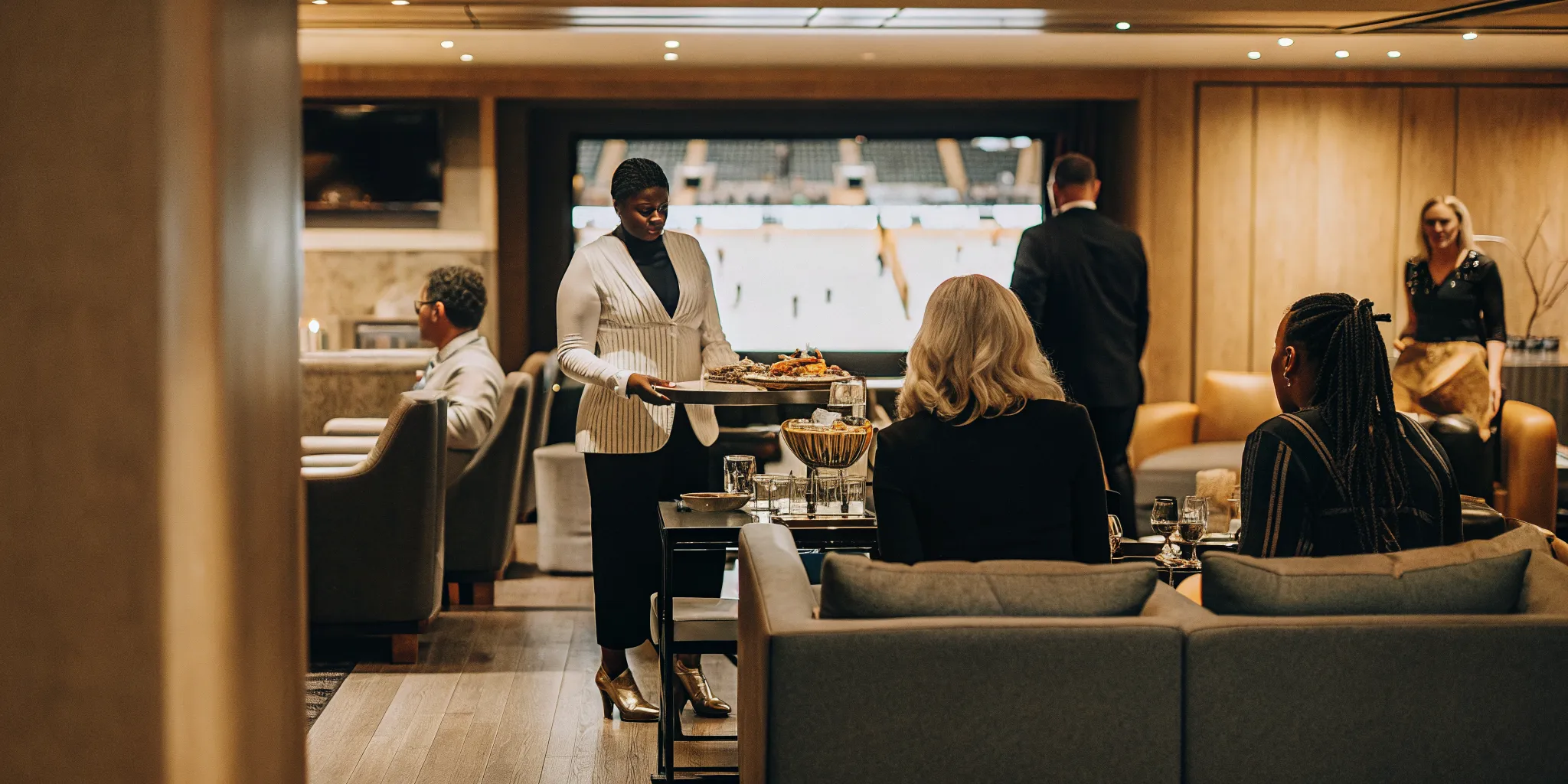 VIP concierge welcoming guests in a premium suite lounge at the Final Four
