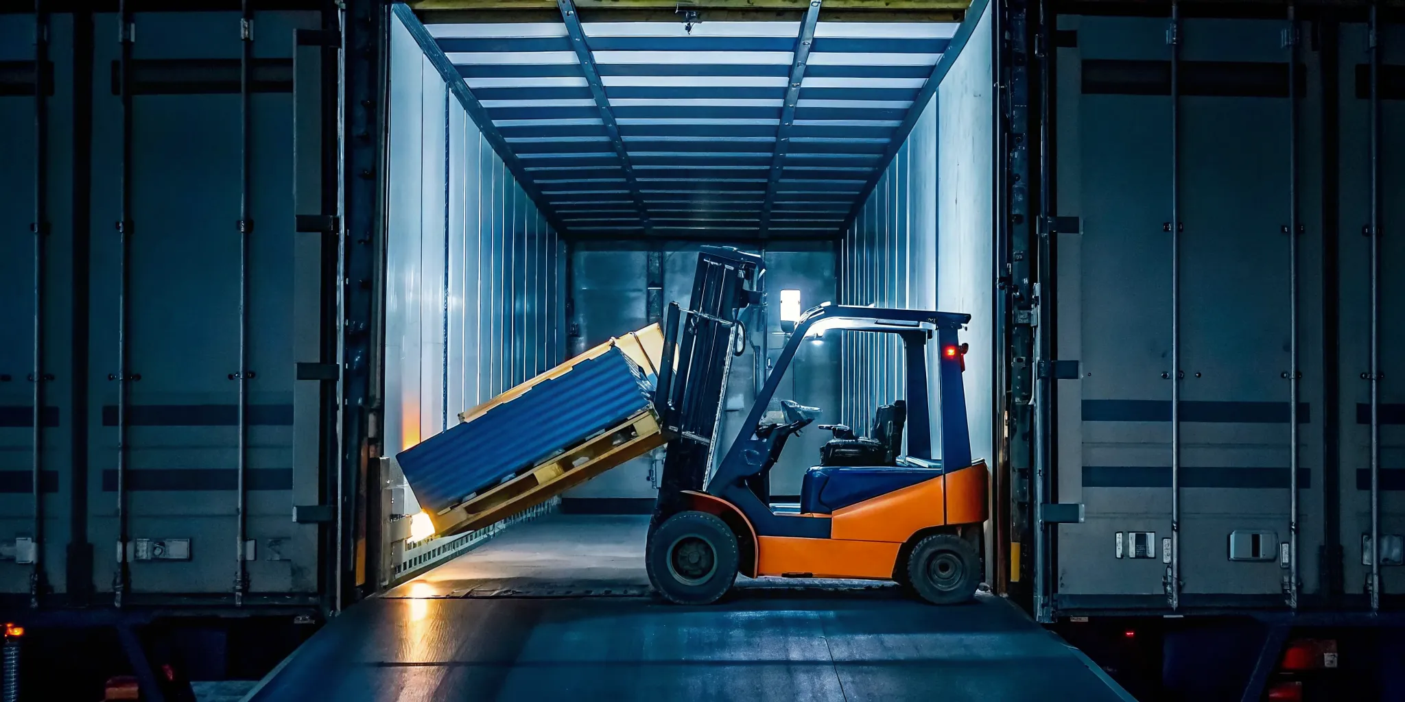 A warehouse forklift lifting a tilted pallet inside a trailer
