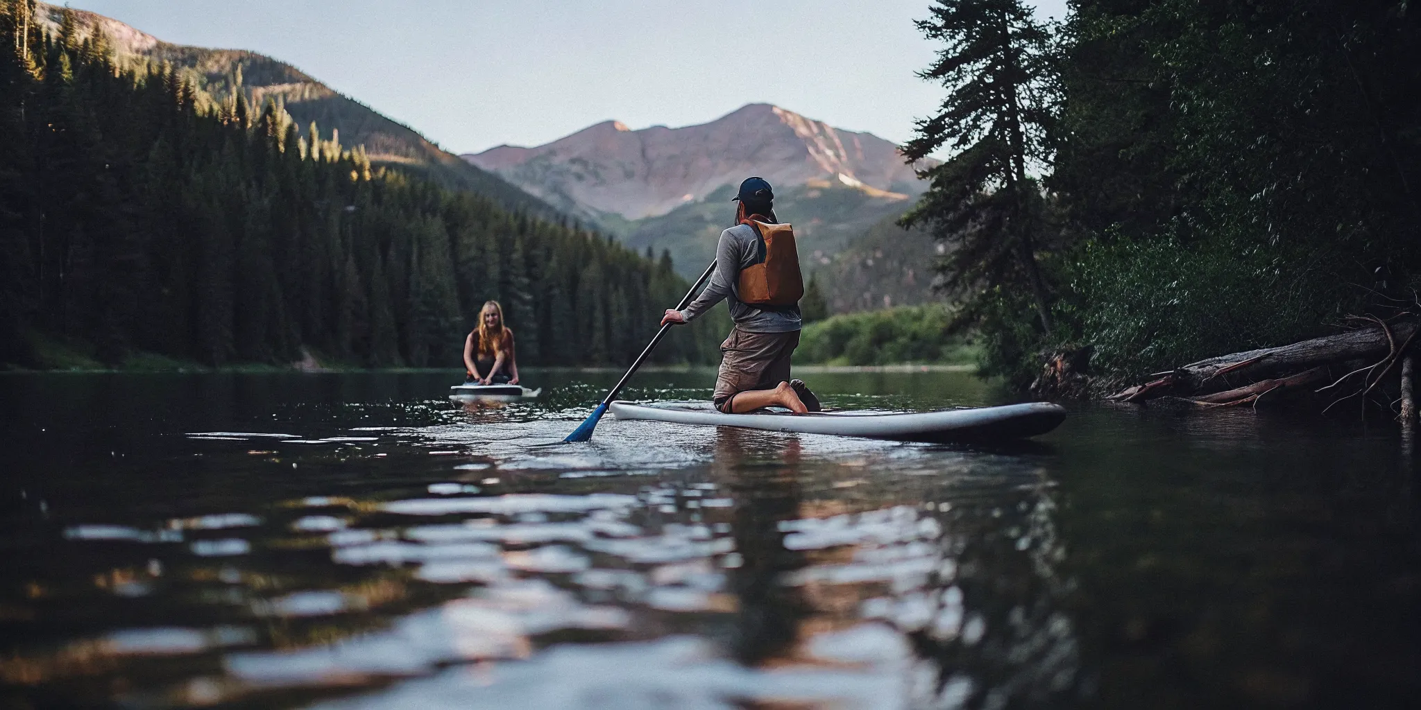 Beginner paddle boarder wearing a flotation device on a calm Colorado lake