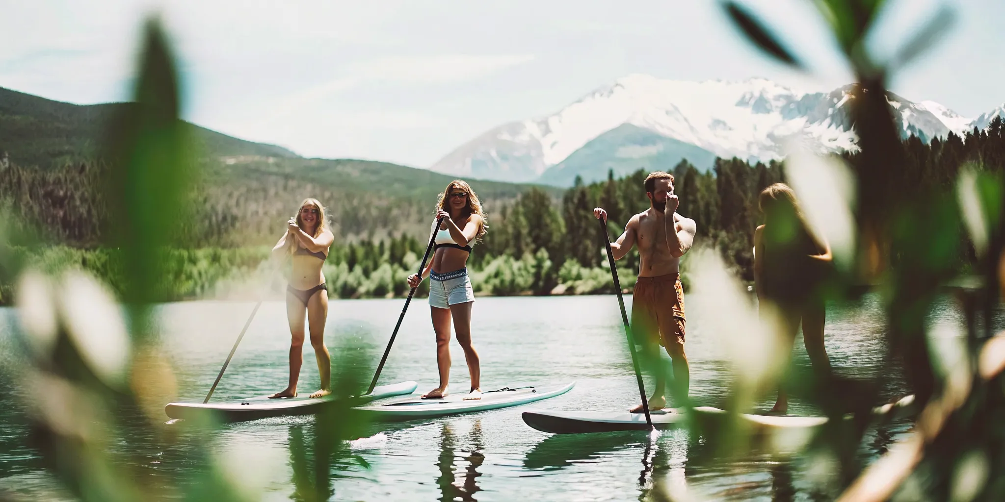 Group of friends stand-up paddleboarding together on Lake Dillon with Rocky Mountain peaks in the background