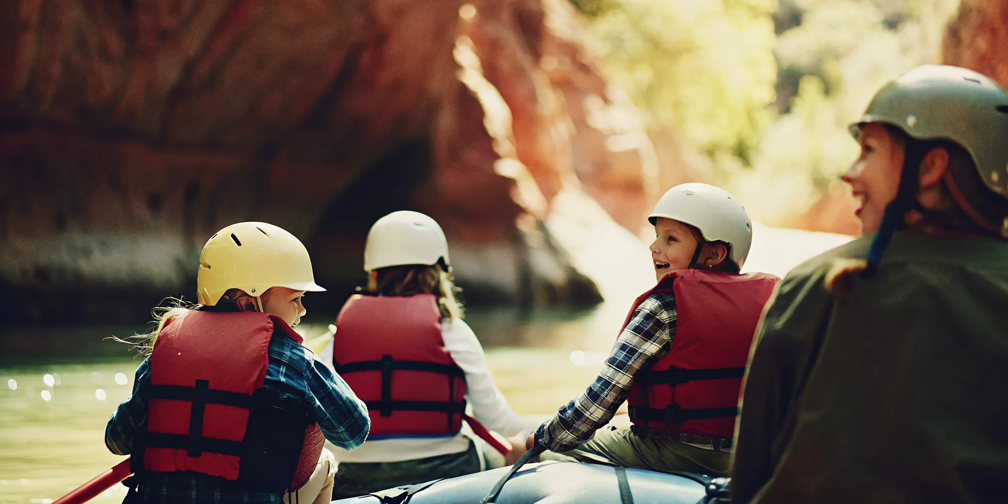 Family raft splashing through Class II rapids on the Upper Colorado River near State Bridge with life jackets and helmets