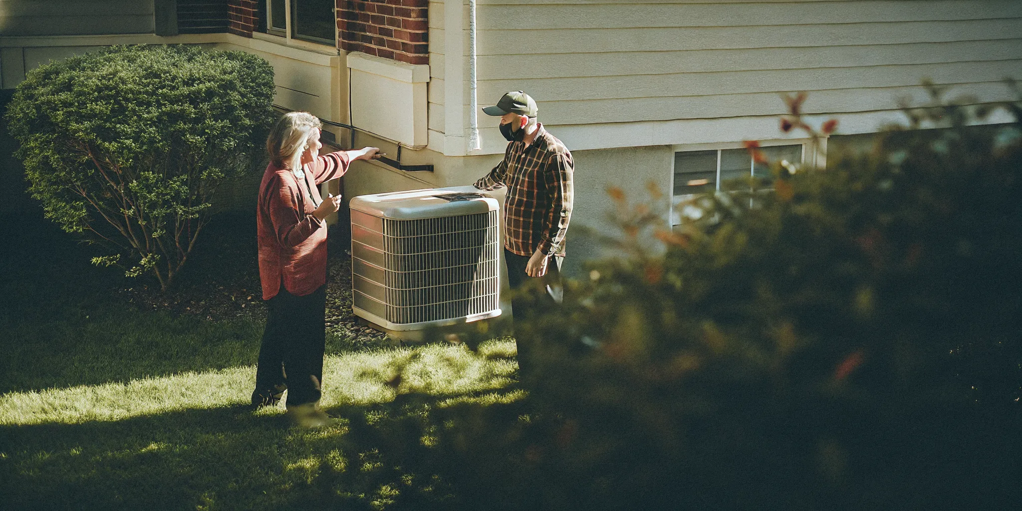 Delmarva homeowner discussing HVAC repair or replacement with a technician