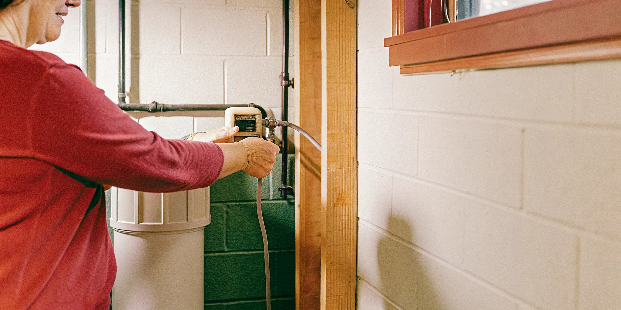 Homeowner inspecting a residential water softener control valve
