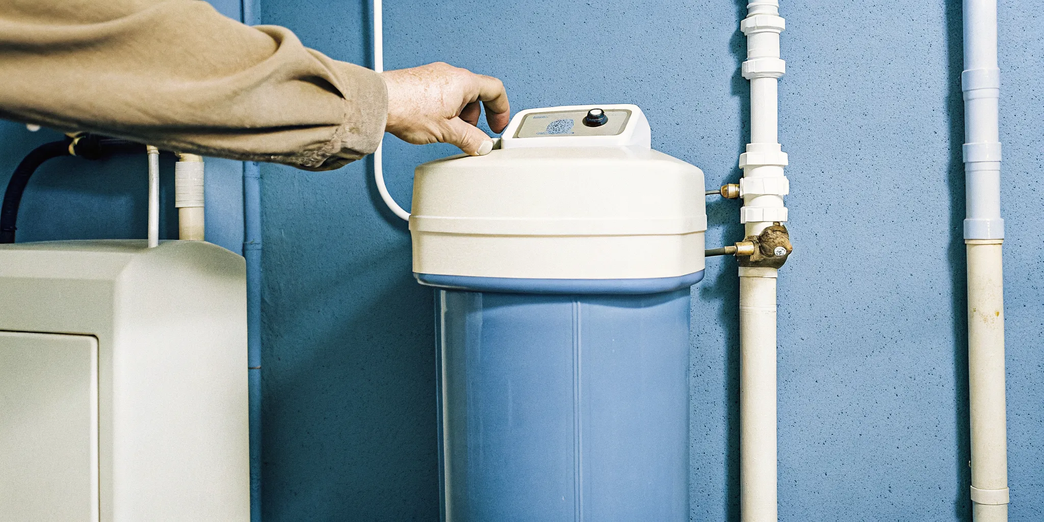 Homeowner checking a residential water softener during routine maintenance