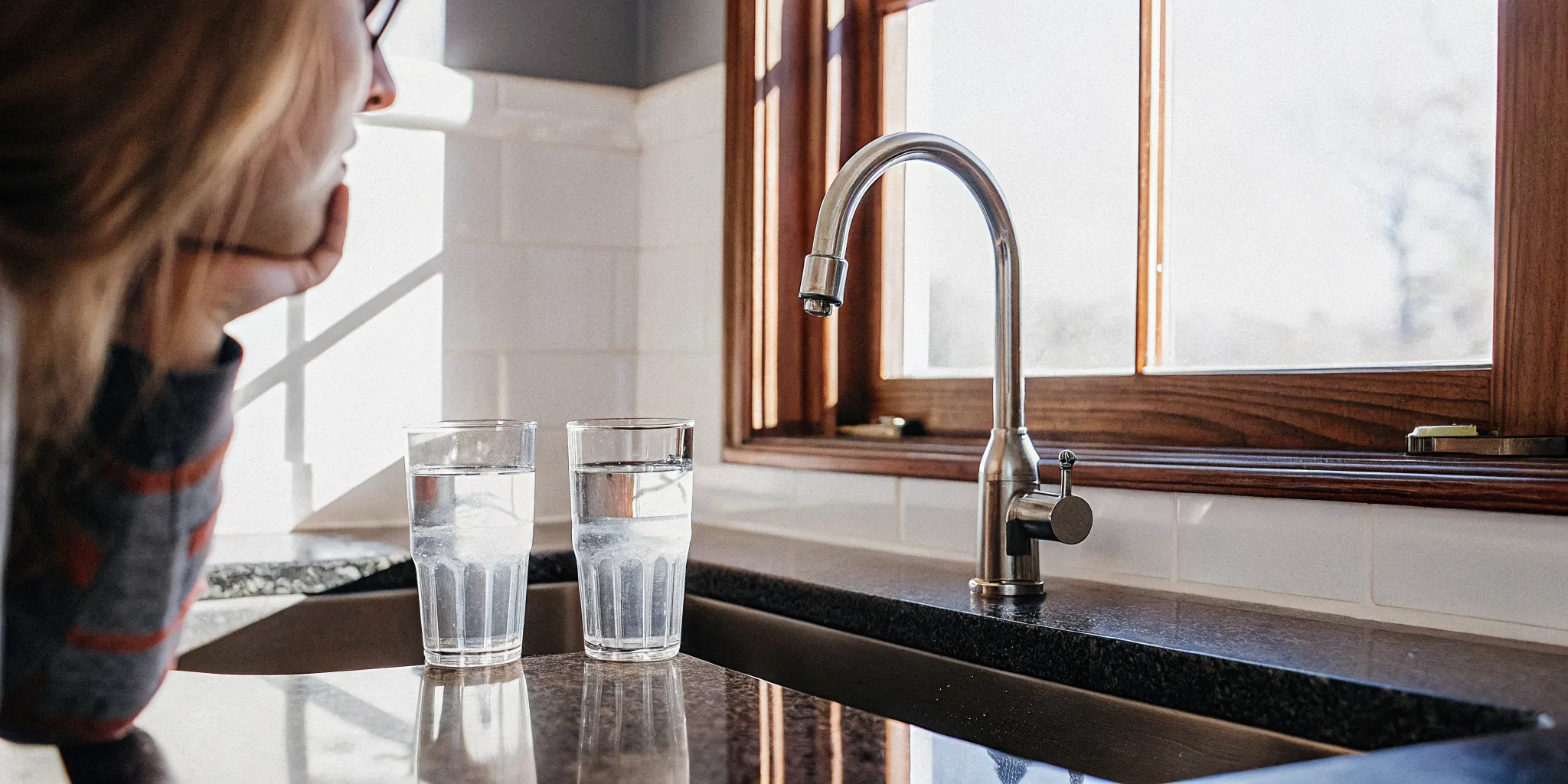 Homeowner comparing hot and cold tap water