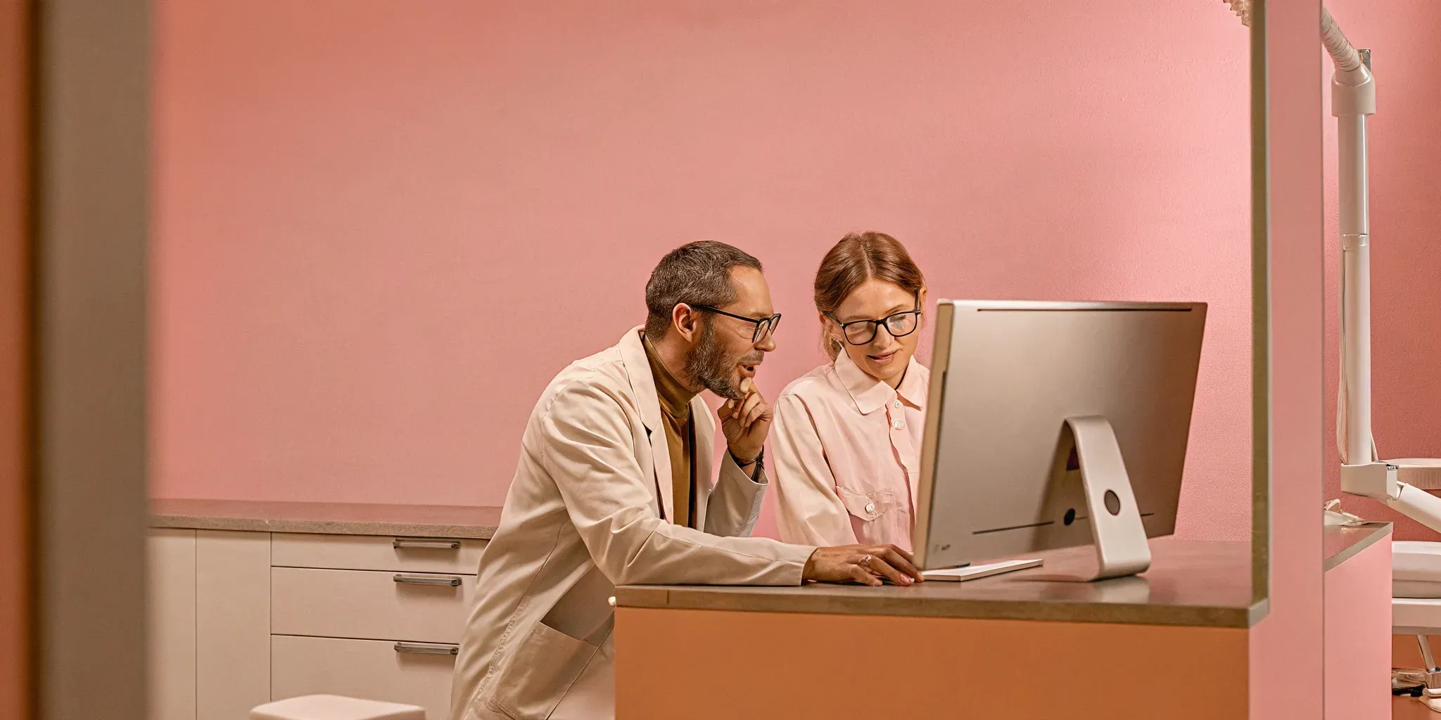 Practice managers reviewing multi-site analytics dashboard on a monitor