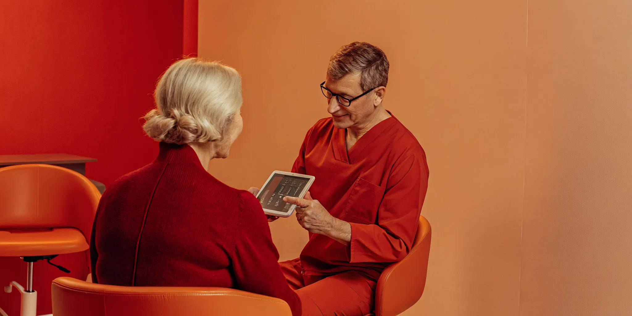 Oral surgeon reviewing CBCT scan data on a tablet during patient consultation
