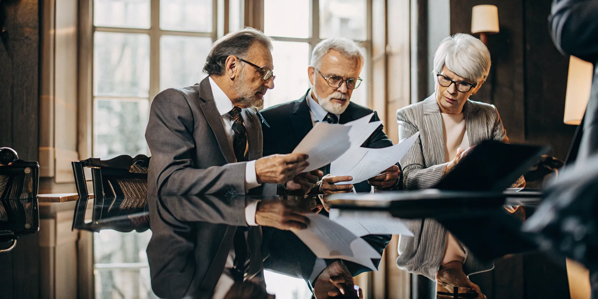 Senior attorneys reviewing shareholder disputes documents in a California conference room