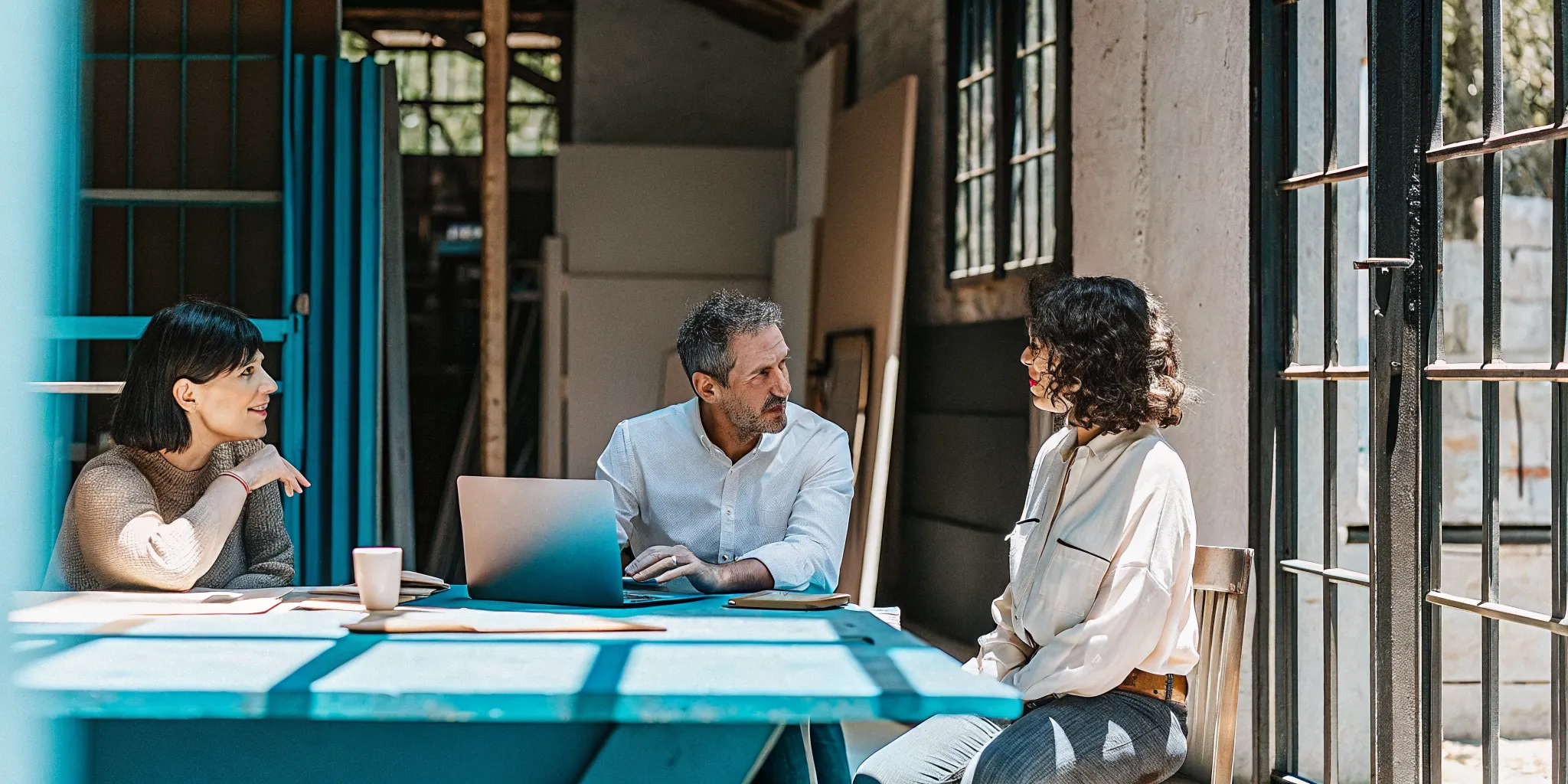 Two small business owners comparing financing options with a financing specialist