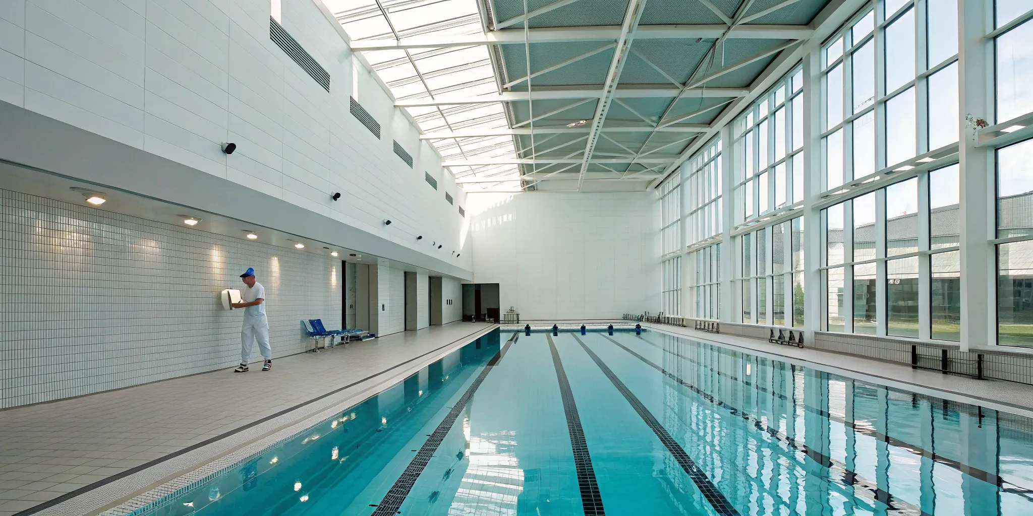 A lifeguard watches a pool as digital lifeguard technology works to detect swimmers in distress.