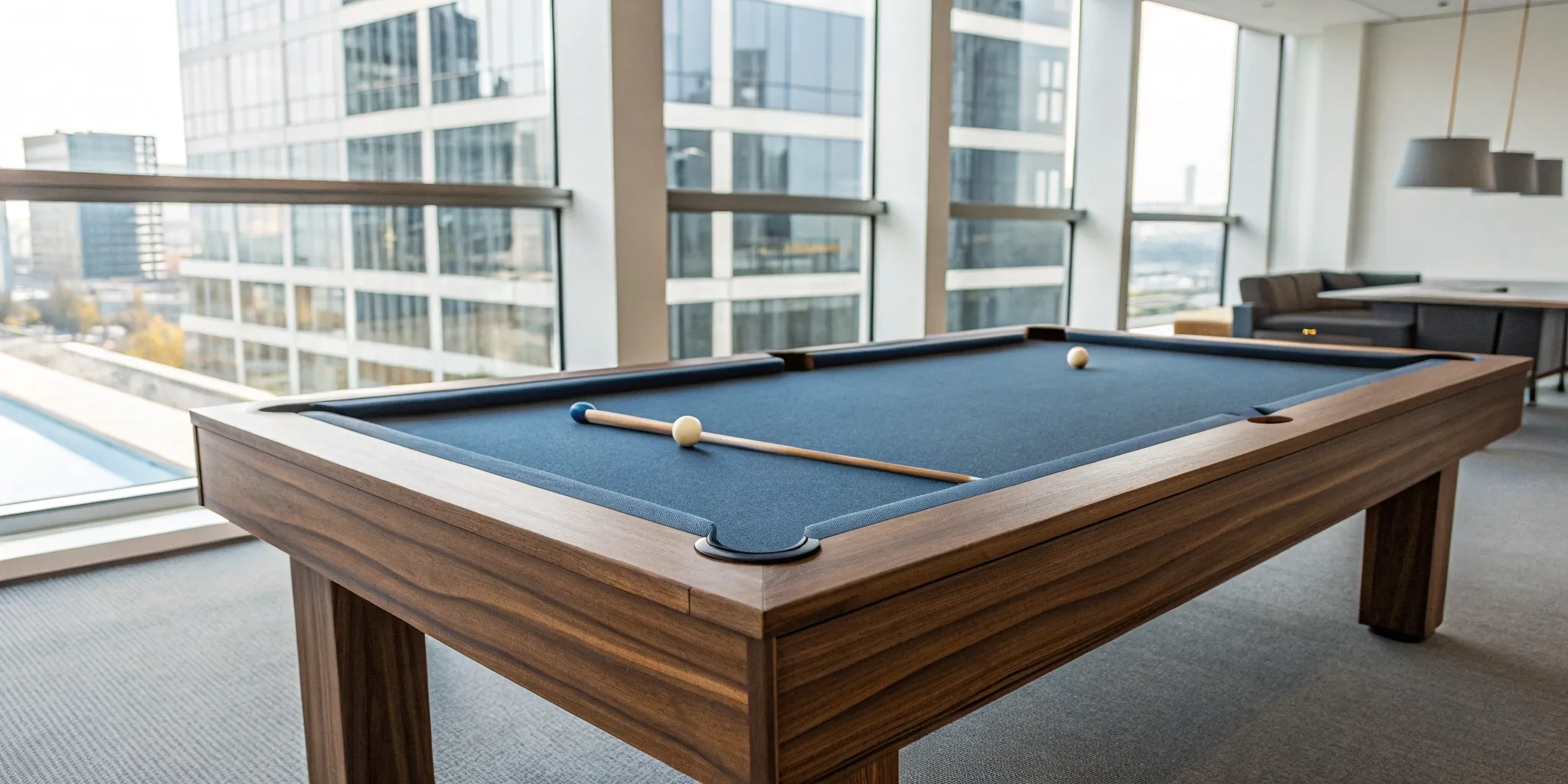 A blue felt pool table with racked balls and a cue stick, ready to play.