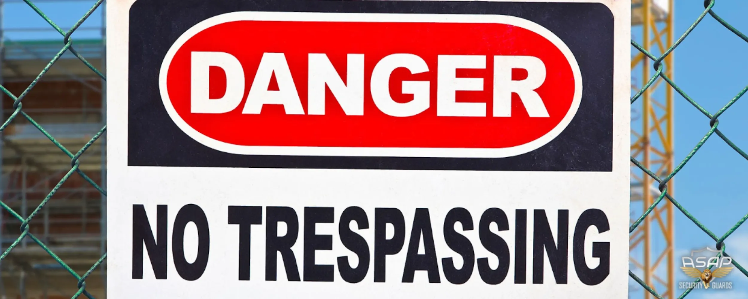 No trespassing sign on a chain link fence at a construction site