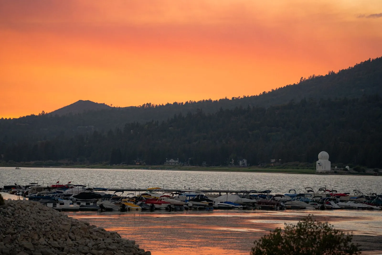 Boats gathered along a California lake at sunset