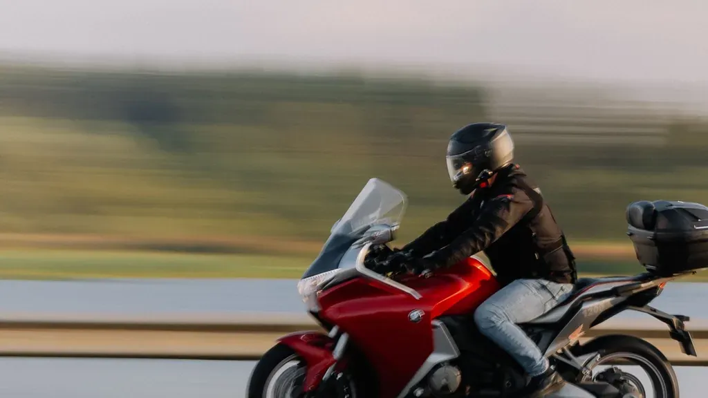 Motorcyclist riding in full protective gear on a California roadway