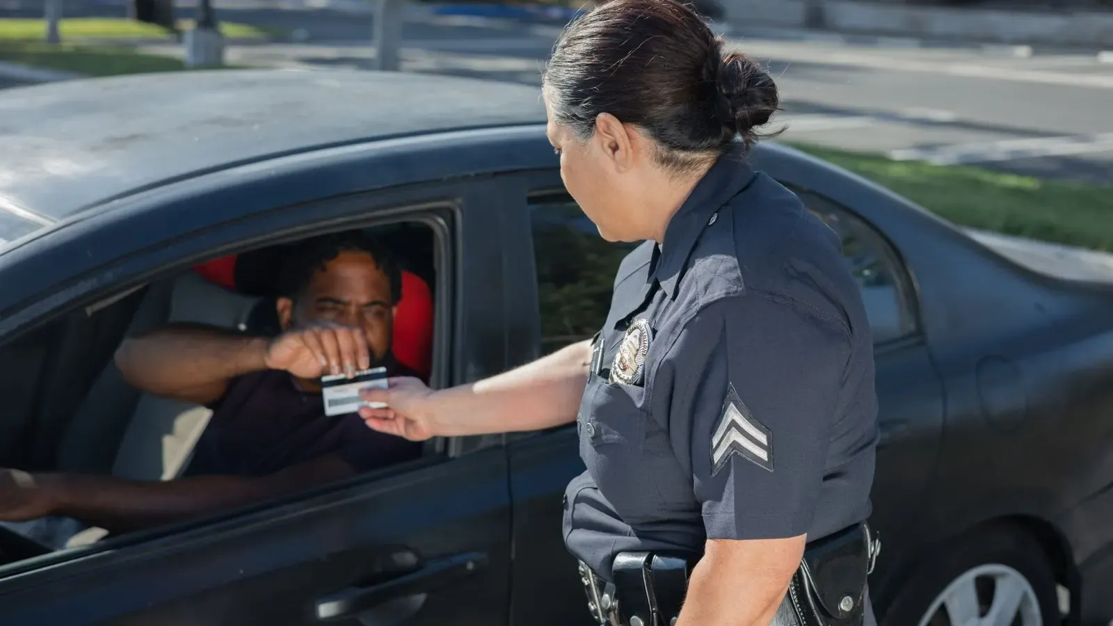 California driver and law enforcement officer exchanging identification after a collision