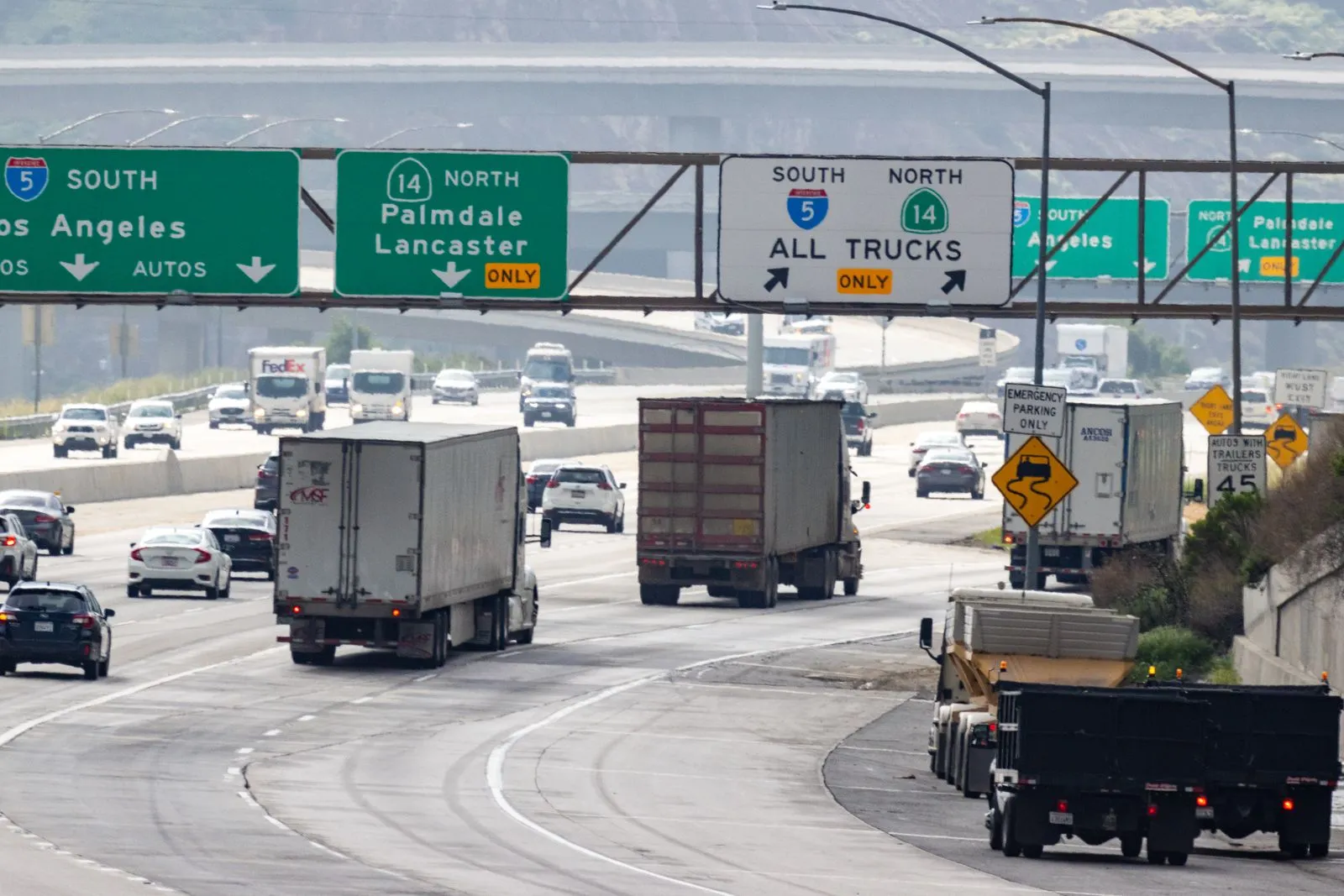 Commercial trucks and passenger vehicles traveling on a busy highway