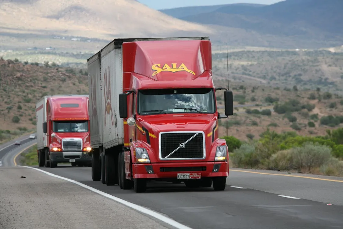 Commercial trucks on a California highway illustrating the size and weight difference versus passenger vehicles