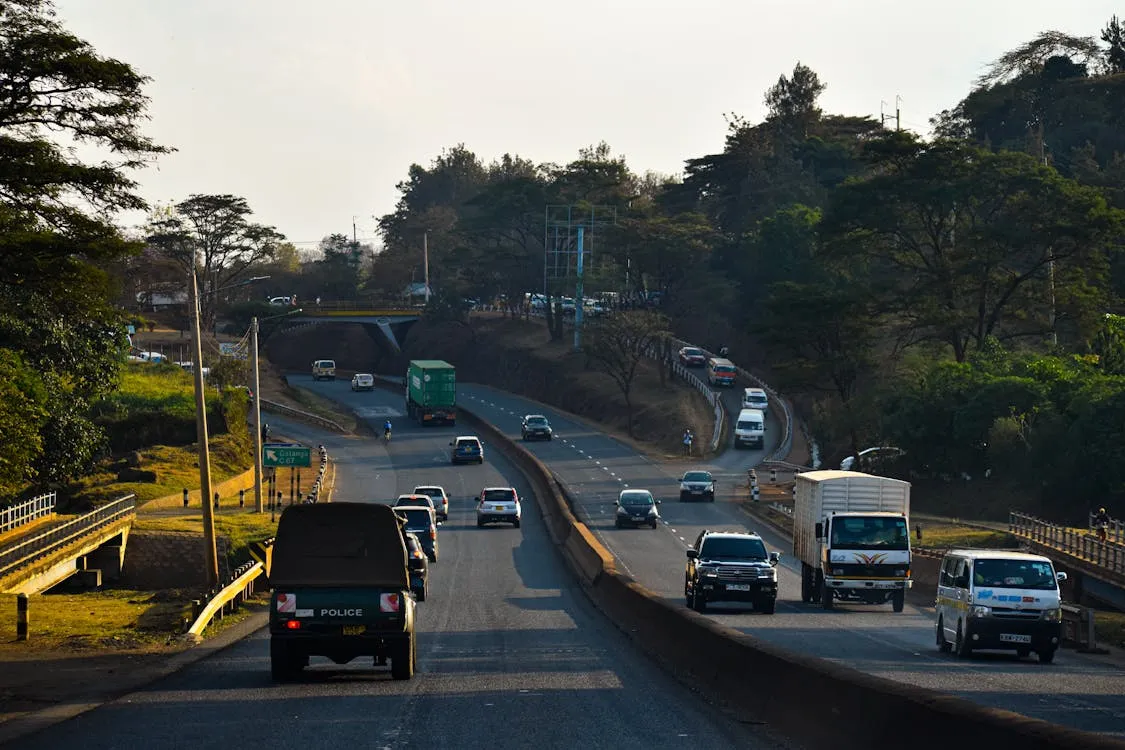 Multiple commercial trucks and passenger vehicles traveling on a California freeway corridor