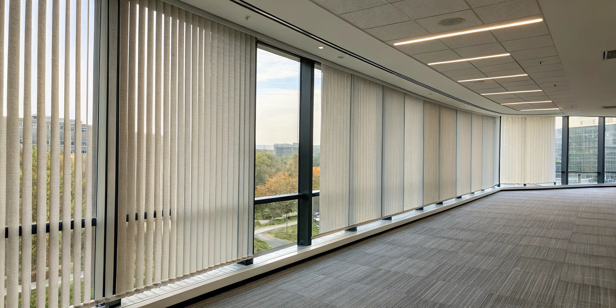 Fabric vertical blinds on large office windows for light control and privacy.