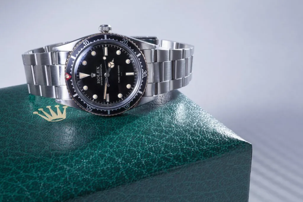 A Rolex watch displayed on its green presentation box