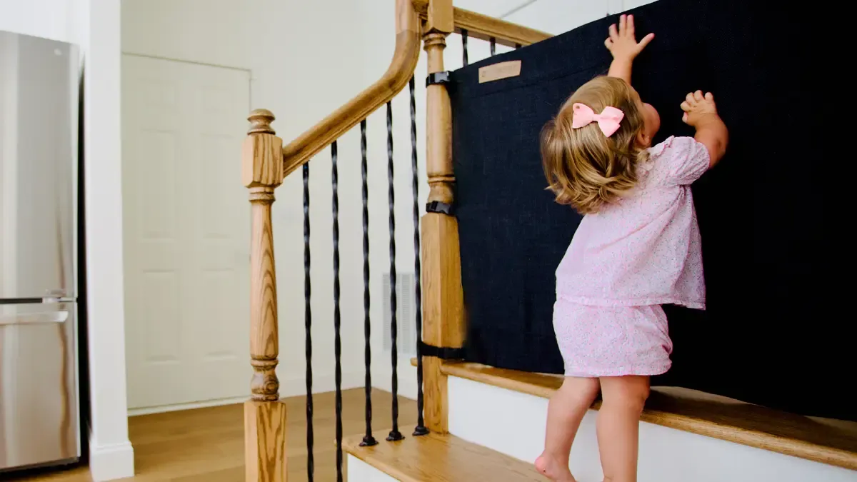 Wall-to-Banister fabric gate in a thoughtfully babyproofed home