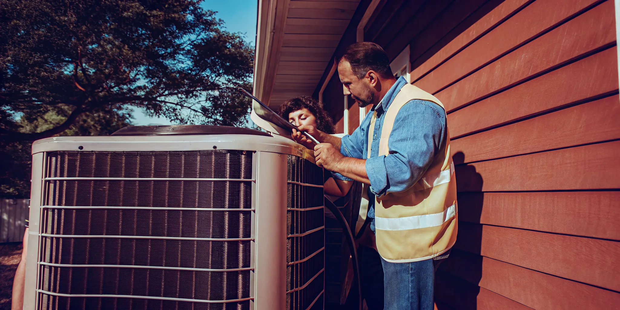 Technician inspecting an outdoor condenser for an AC running but not cooling