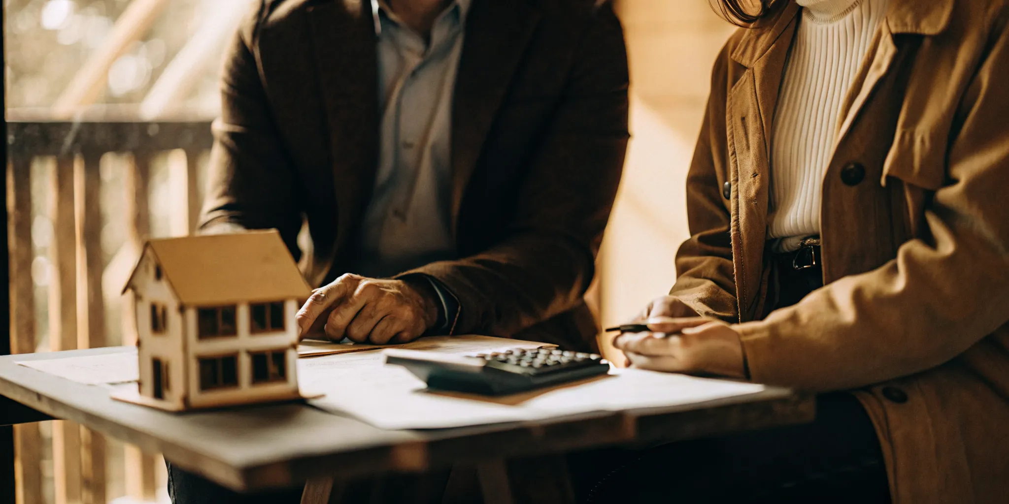 A mortgage advisor and homebuyer comparing a monthly USDA or FHA payment plan at a clean table