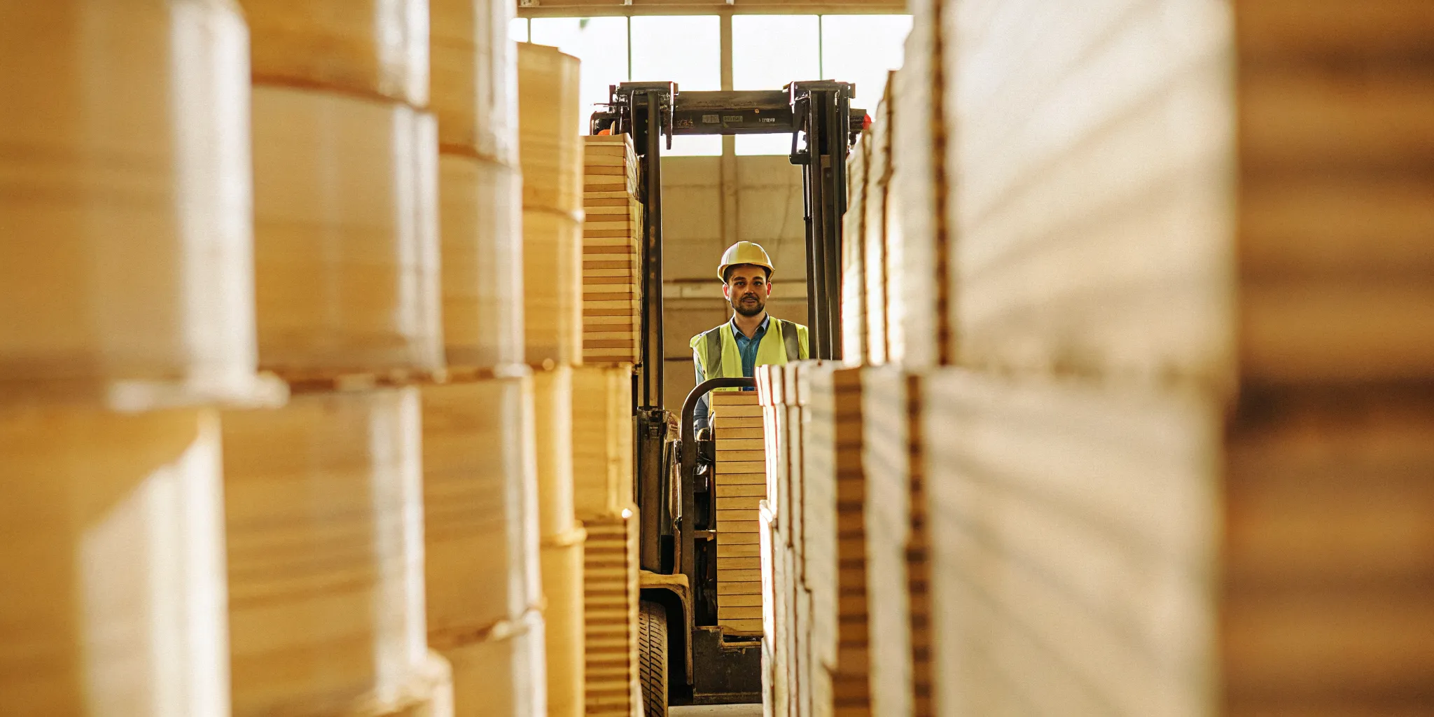 A professional forklift operator operating an indoor warehouse forklift in Massachusetts