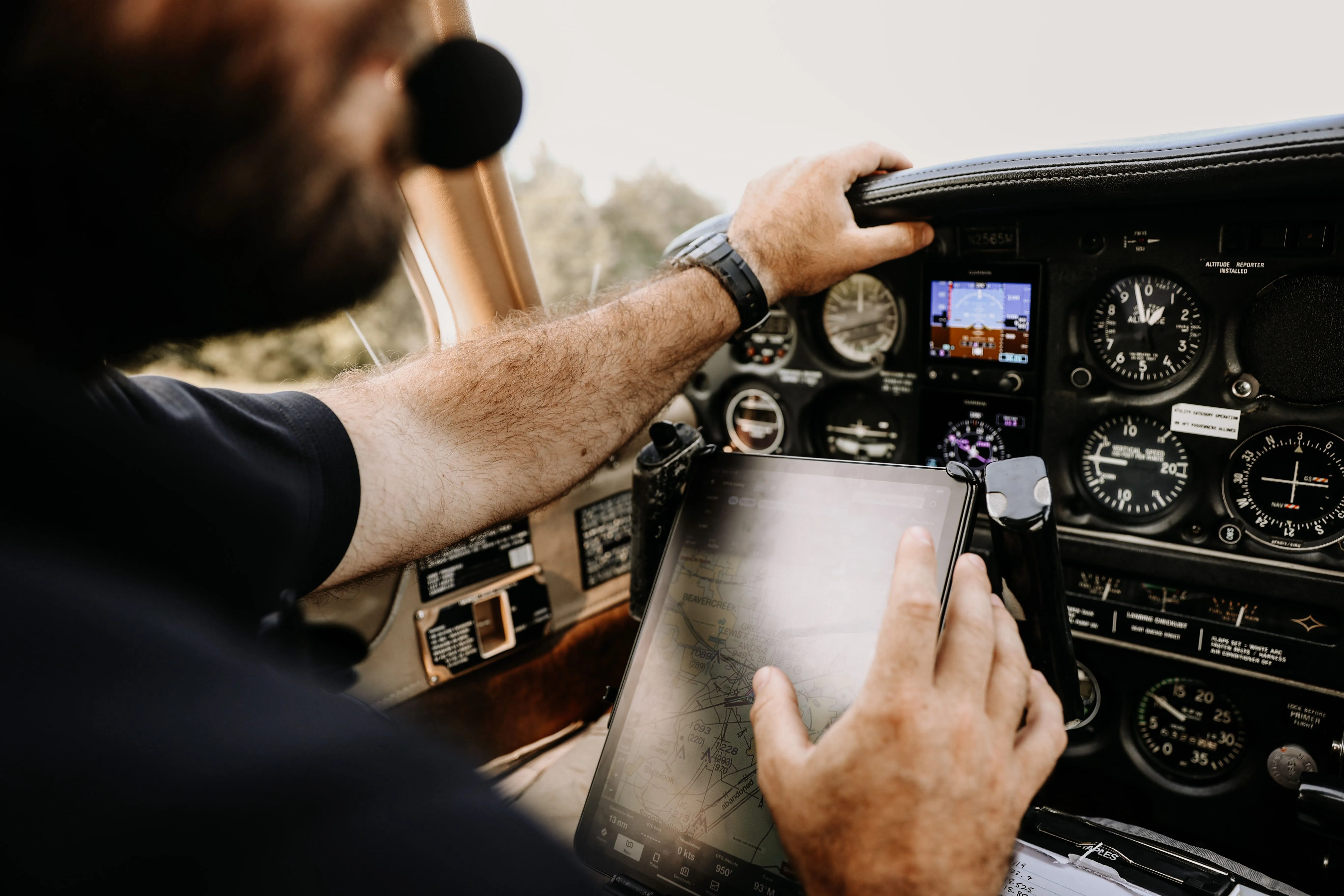 Pilot using navigation tablet in an aircraft cockpit with instruments and avionics
