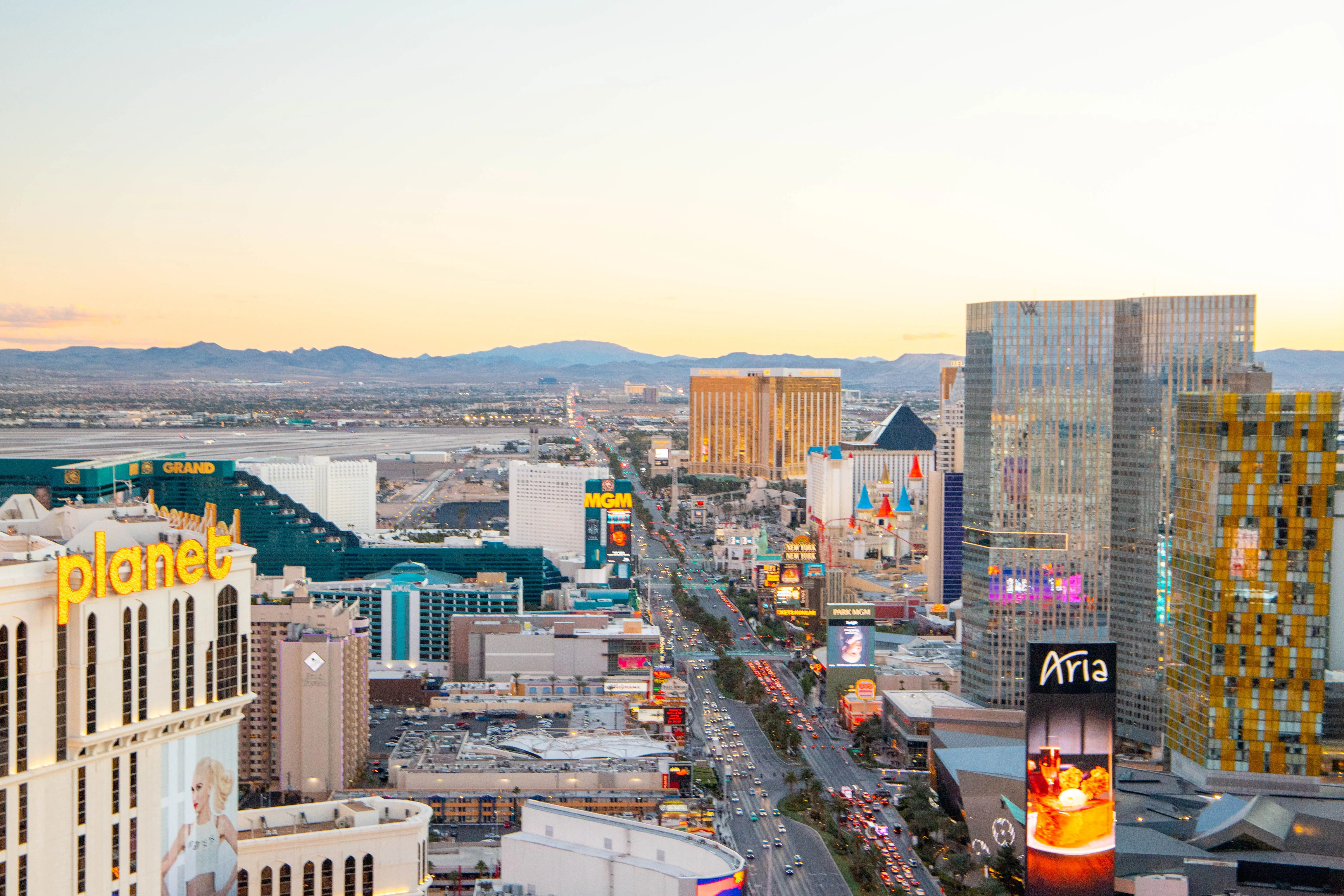 Aerial view of the Las Vegas Strip skyline at sunset with city lights and surrounding desert landscape