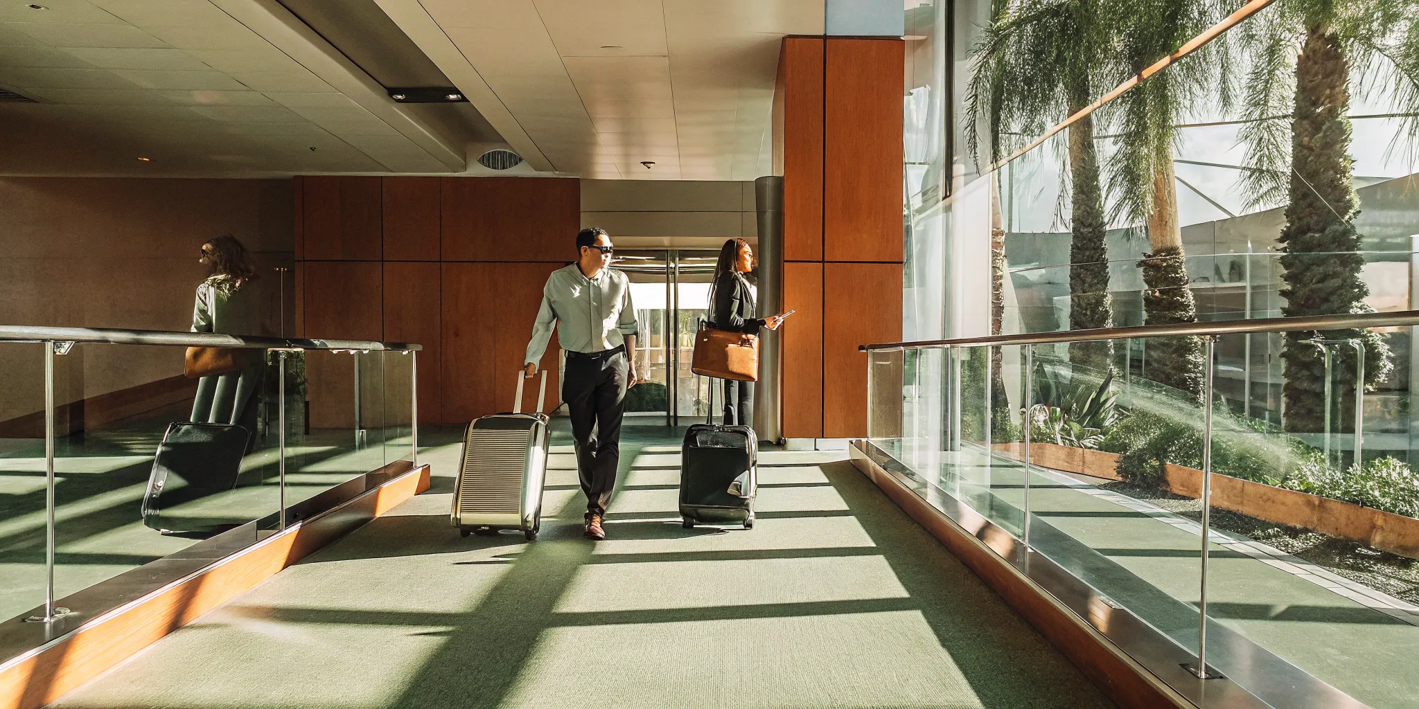 Traveler with luggage heading toward a waiting professional driver at LAX arrivals