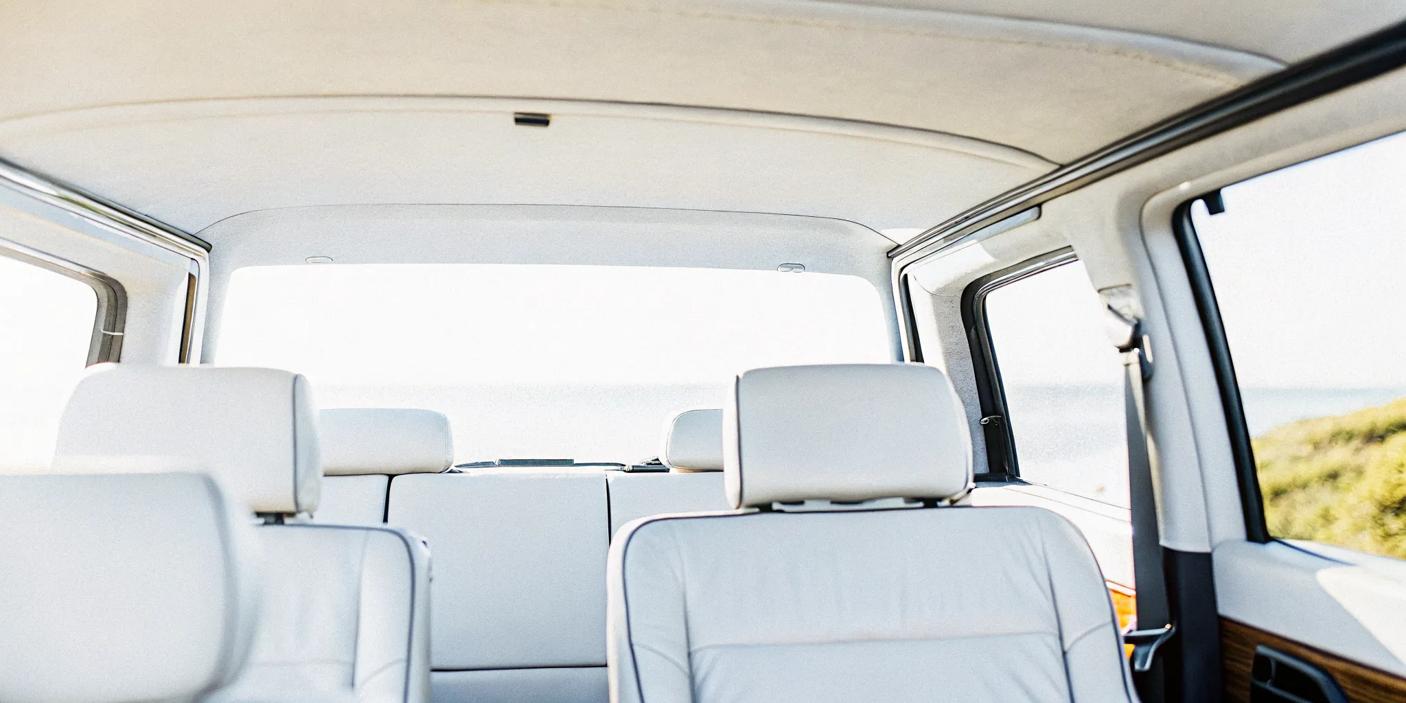 A comfortable modern private van interior with clean leather seats and spacious legroom