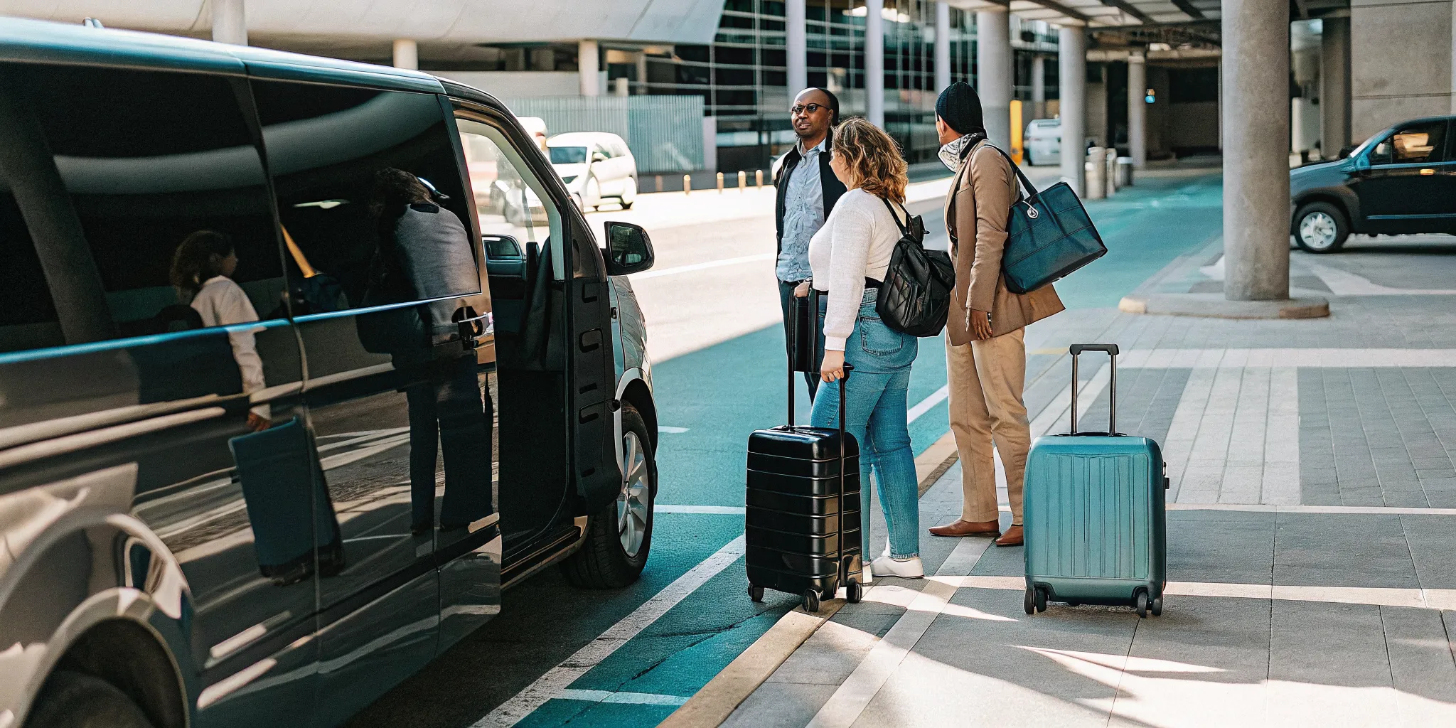 Travelers meeting a private van for LAX airport pickup at the terminal curb