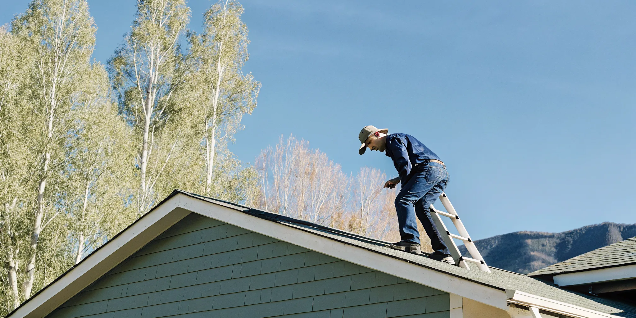 Professional inspecting asphalt shingles in Southwest Colorado before roof rejuvenation