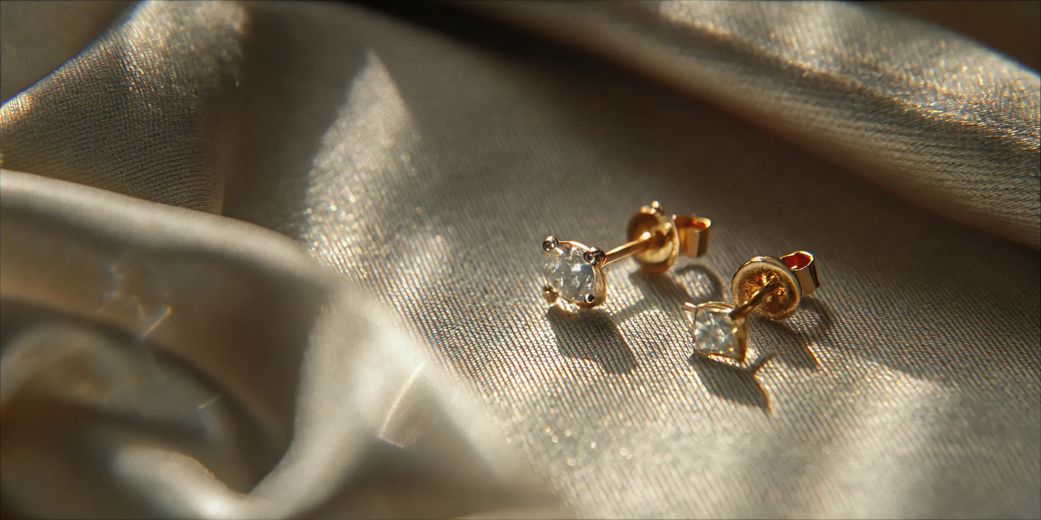 Secure diamond earring settings and backs beside a jewelry care cloth